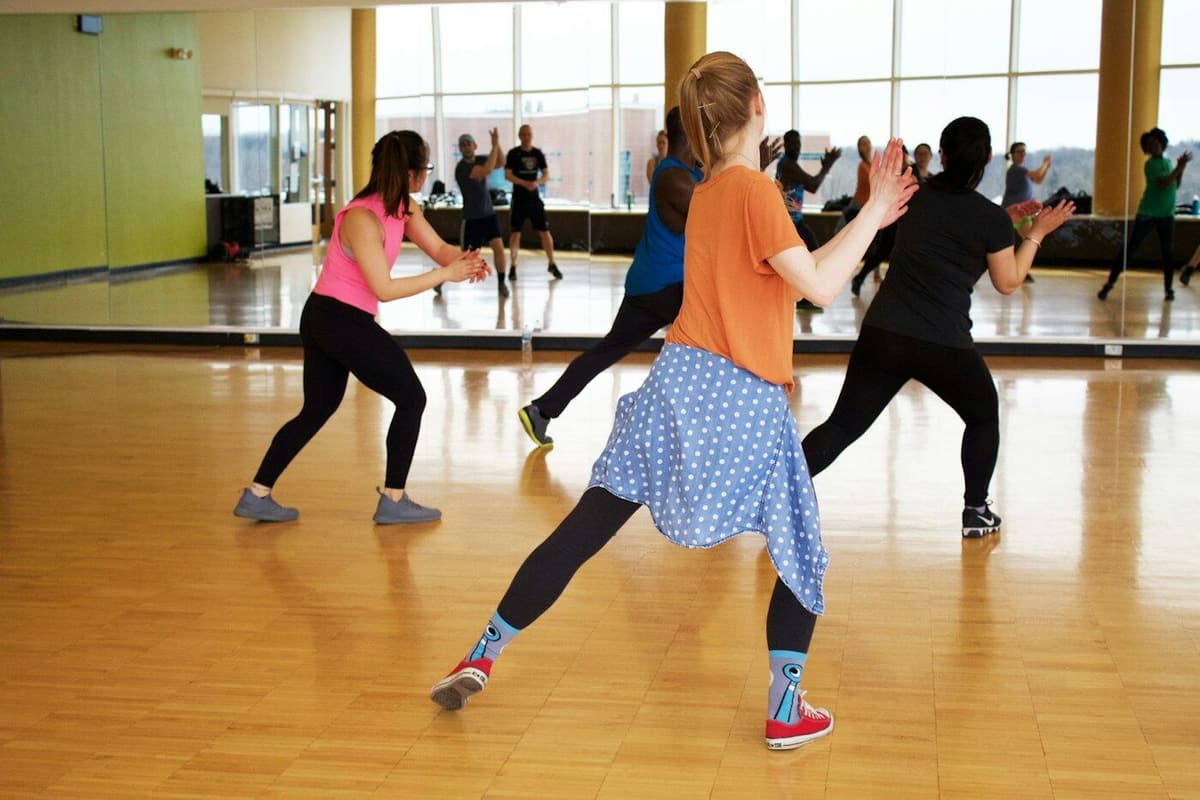 Aula de dança num studio com espelhos e chão de madeira