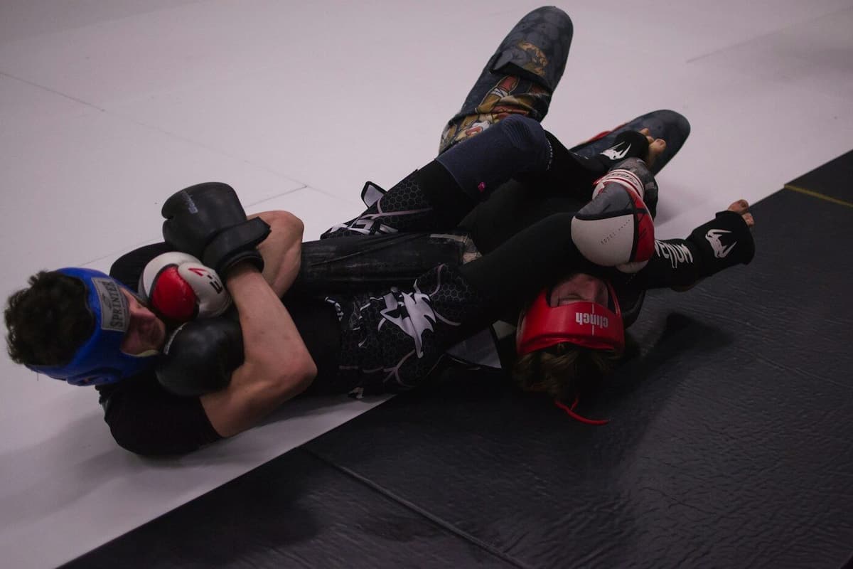 Dois atletas de jiu-jitsu a treinar no tatami