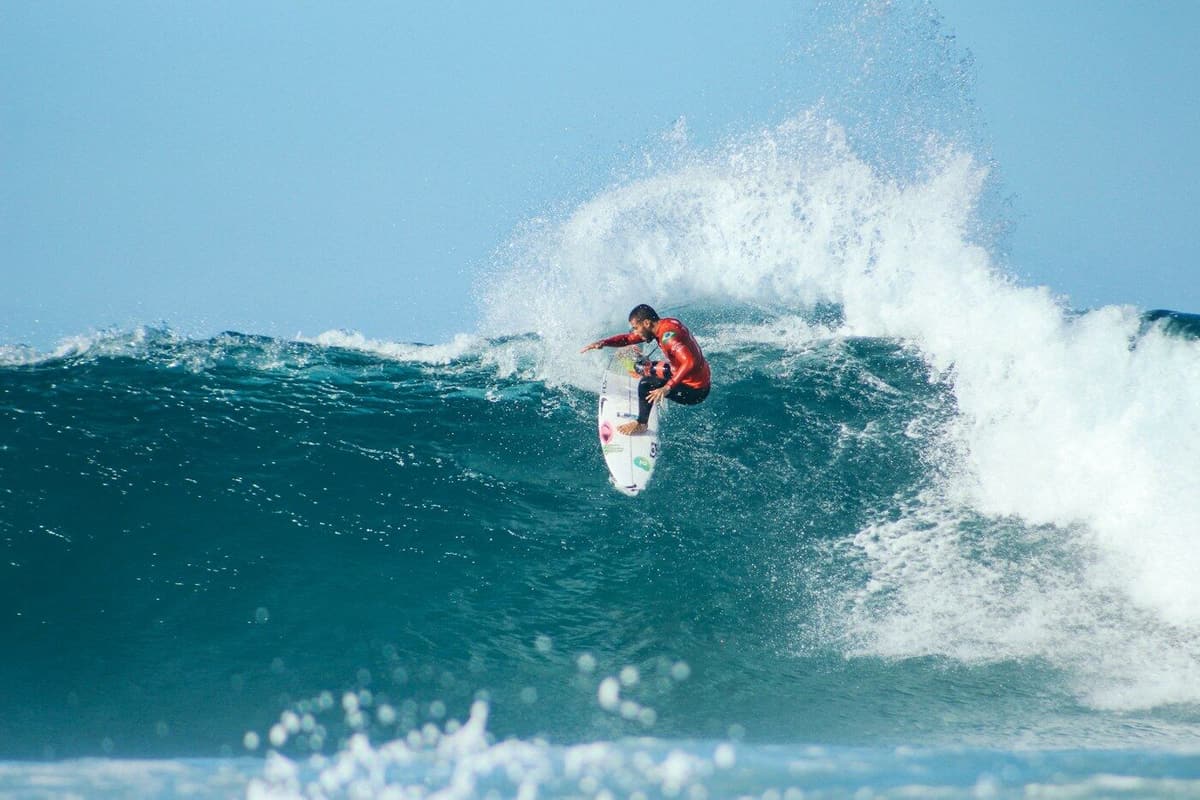 Surfista a apanhar uma onda azul-esverdeada