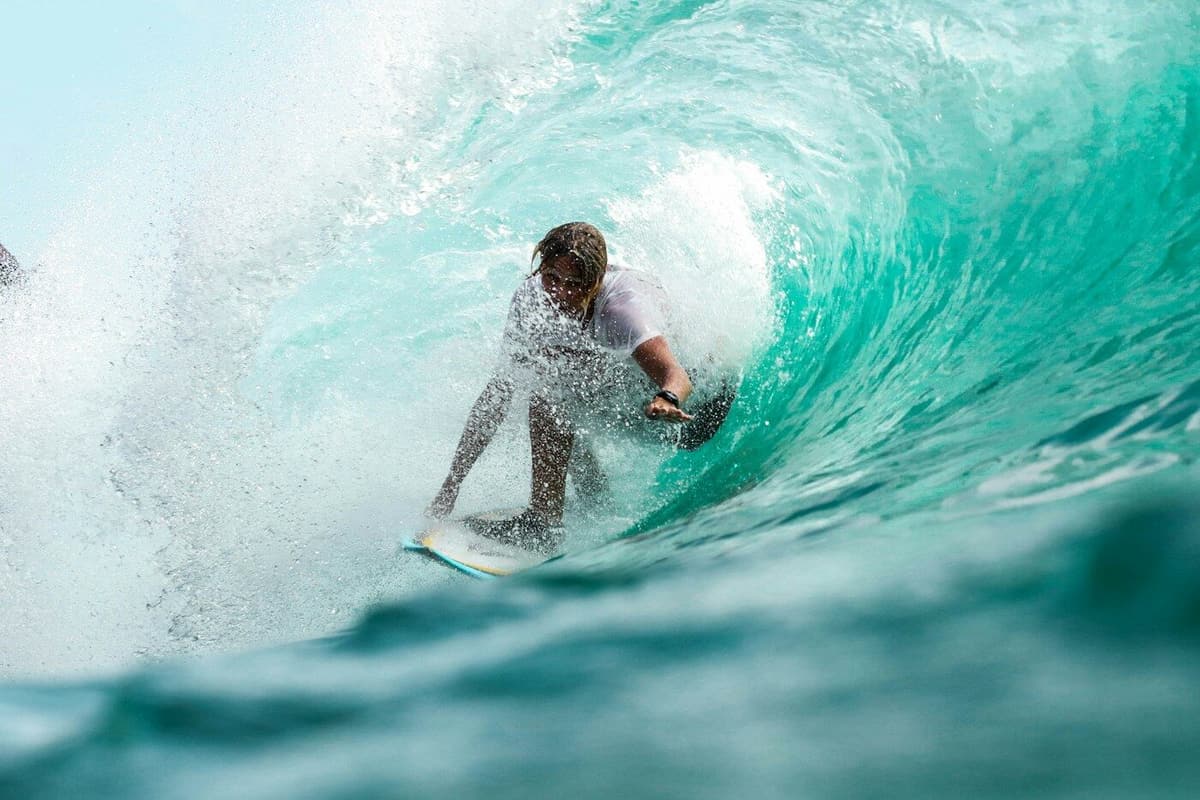 Surfista dentro de uma onda a rebentar